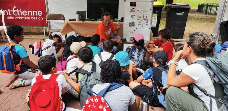 un groupe d'enfants qui écoutent la présentation d'un adulte