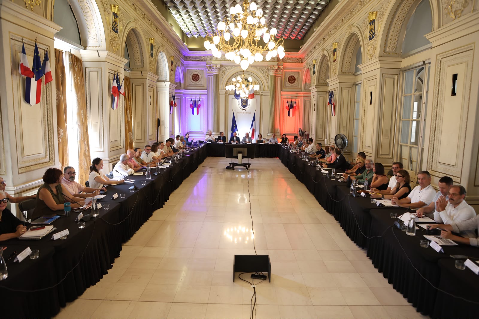 une réunion avec de nombreuses personnes assises à des tables 