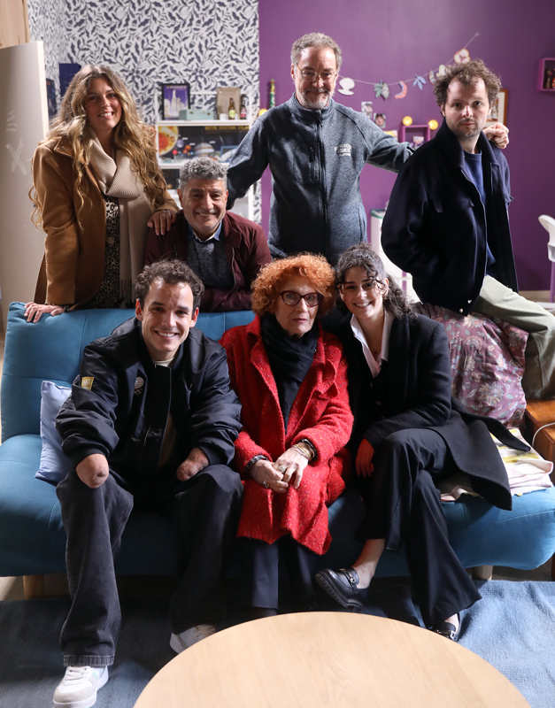 7 personnes souriantes dans un salon d'appartement