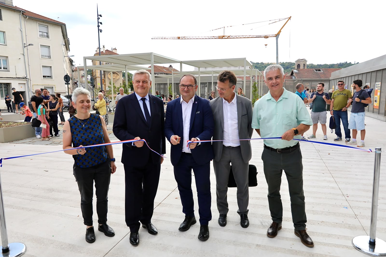 un groupe qui coupe un ruban sur une place