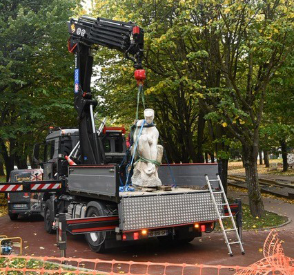 un camion qui déplace une statue