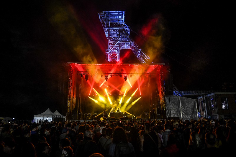 concert de nuit avec un chevalement éclairé en arrière-plan