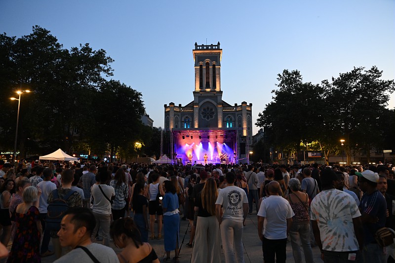 une foule devant un concert, une cathédrale en arrière-plan