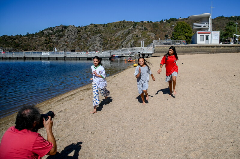 une personne qui filme des jeunes qui courent sur une plage