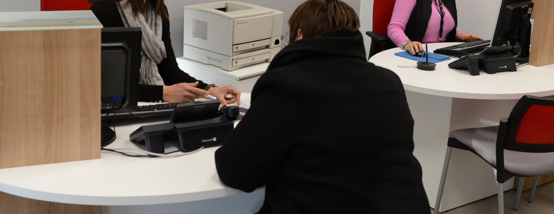 2 agents d'accueil au bureau, en face d'une femme