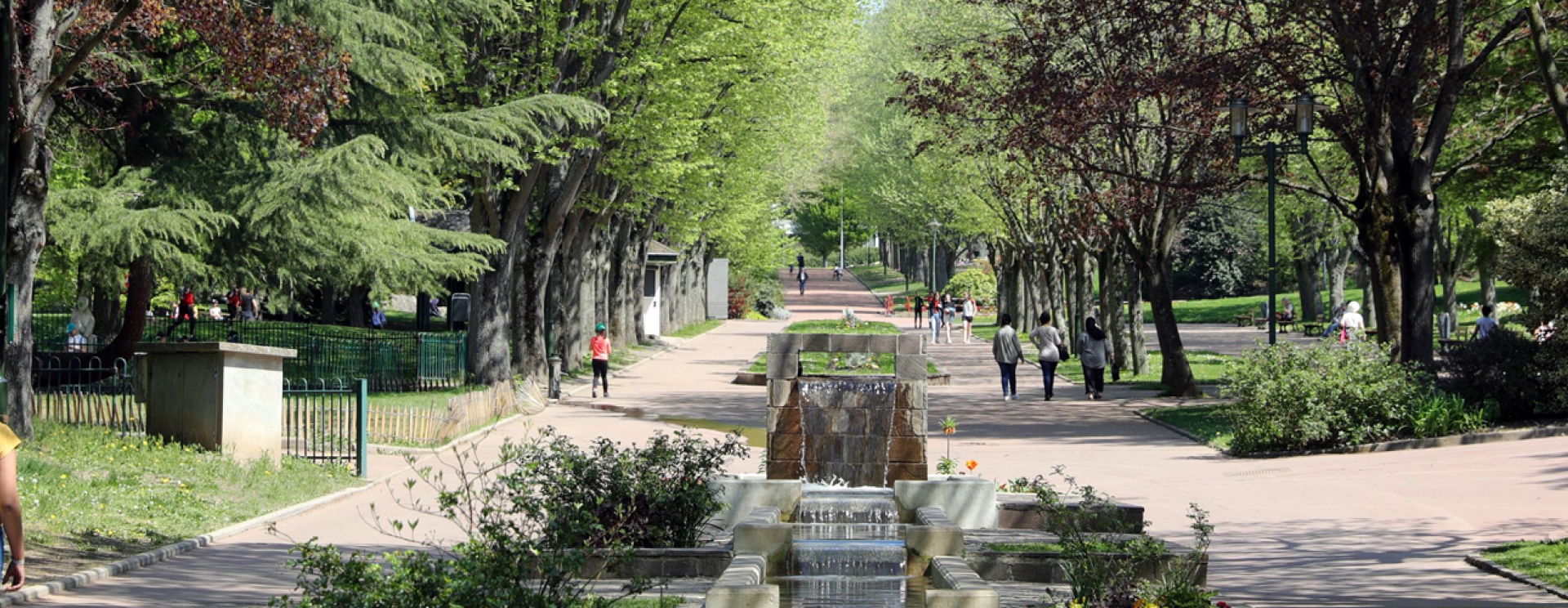 parc urbain avec cours d'eau, grande allée piétonne avec de nombreuses arbres