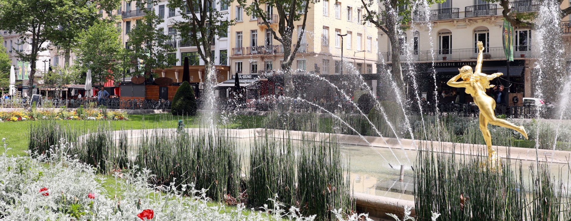 fontaine avec fleurs et statue parée d'or