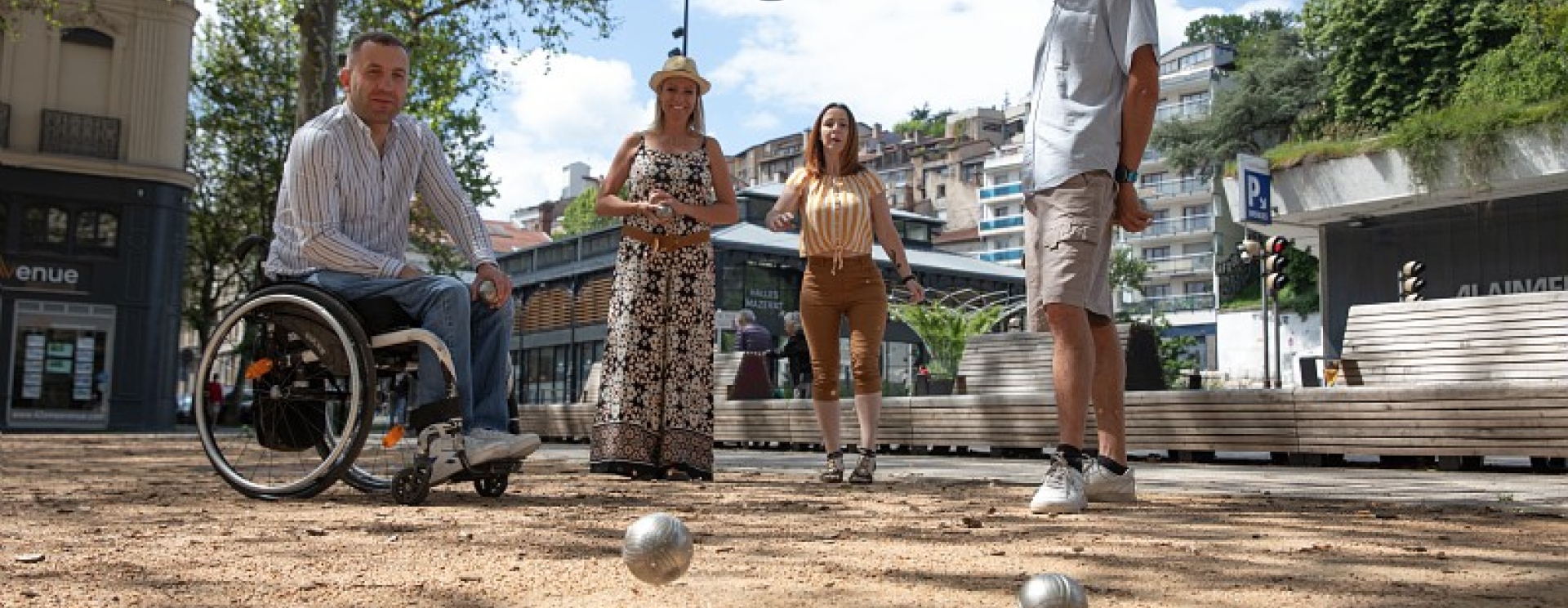 un groupe qui joue à la pétanque dont une personne en fauteuil roulant