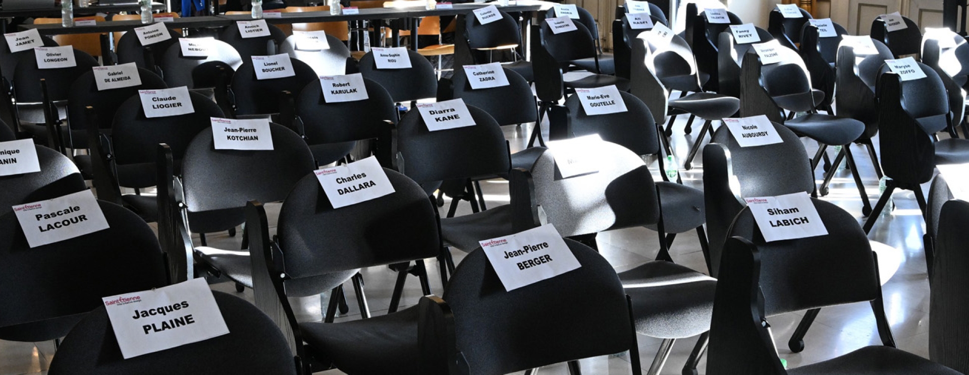 un ensemble des chaises avec pour chacune une feuille avec un nom