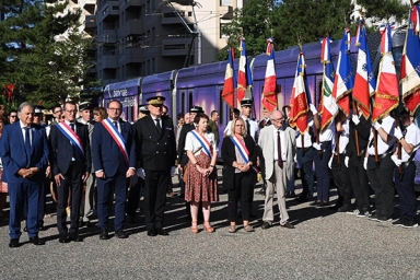 un groupe avec des élus et des drapeaux français commémoratifs 