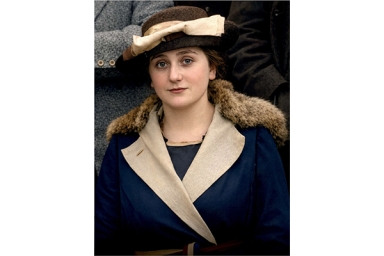 une femme avec un chapeau et un manteau en partie en fourrure 