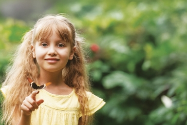 une jeune fille qui a un papillon sur le doigt 