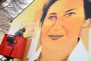 une fresque avec une femme peinte sur un mur par un homme