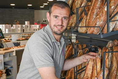 un homme avec des baguettes de pain à la main