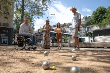 un groupe qui joue à la pétanque dont une personne en fauteuil roulant