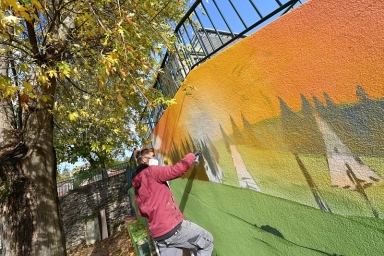 un homme qui réalise une fresque colorée