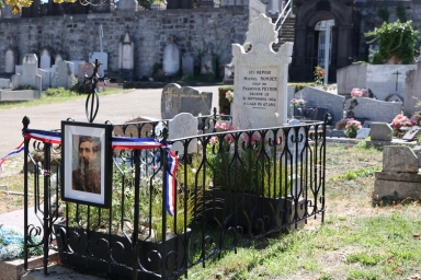 une tombe bien entretenue et entourée d'une barrière avec le portrait d'un homme