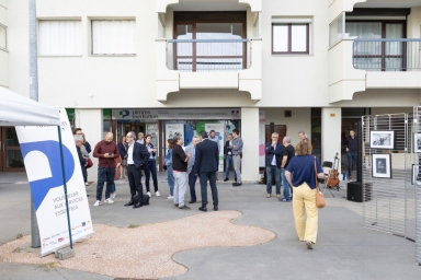 un groupe devant un immeuble avec un local "Pimms" au rez-de-chaussée