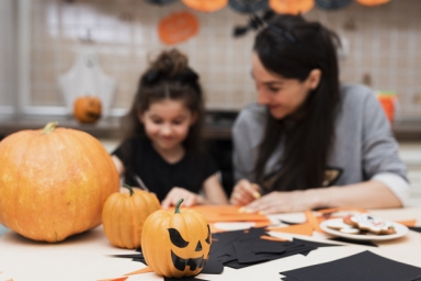 une femme et une enfant lors d'un atelier avec des courges d'Halloween