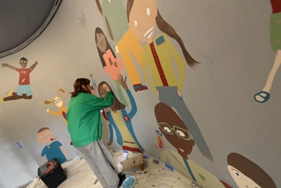 Une femme qui peint des dessins sur un mur - Agrandir l'image 1 sur 3, fenêtre modale