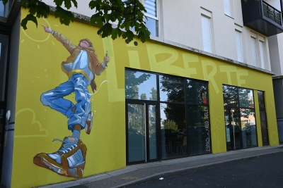 une fresque jaune sur un bâtiment avec le mot liberté et un jeune dessiné - Agrandir l'image 3 sur 3, fenêtre modale