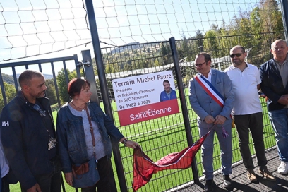 un groupe de personnes dont un maire qui dévoile une plaque intitulée "Terrain Michel Faure" - Agrandir l'image, fenêtre modale