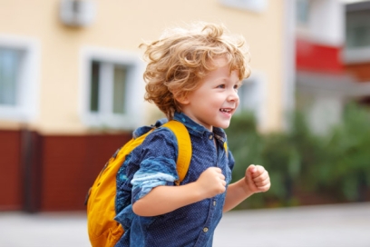 un jeune garçon souriant avec un cartable - Agrandir l'image, fenêtre modale