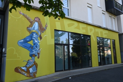 une fresque jaune sur un bâtiment avec le mot liberté et un jeune dessiné - Agrandir l'image, fenêtre modale