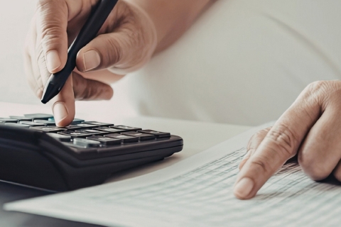 une personne munie d'une calculatrice et d'une feuille de papier