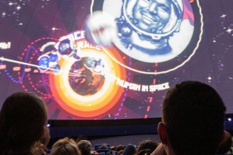 un groupe qui regarde une écran géant avec des planètes