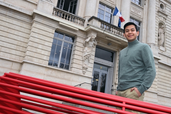 un jeune homme souriant devant un bâtiment - Agrandir l'image, fenêtre modale