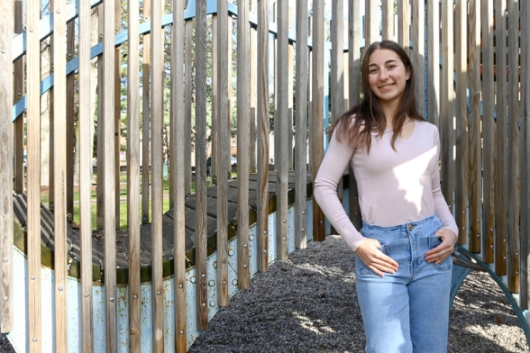 une jeune femme souriante devant un barrière en bois - Agrandir l'image, fenêtre modale