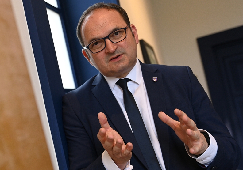 un homme en costume debout qui parle avec ses mains - Agrandir l'image, fenêtre modale