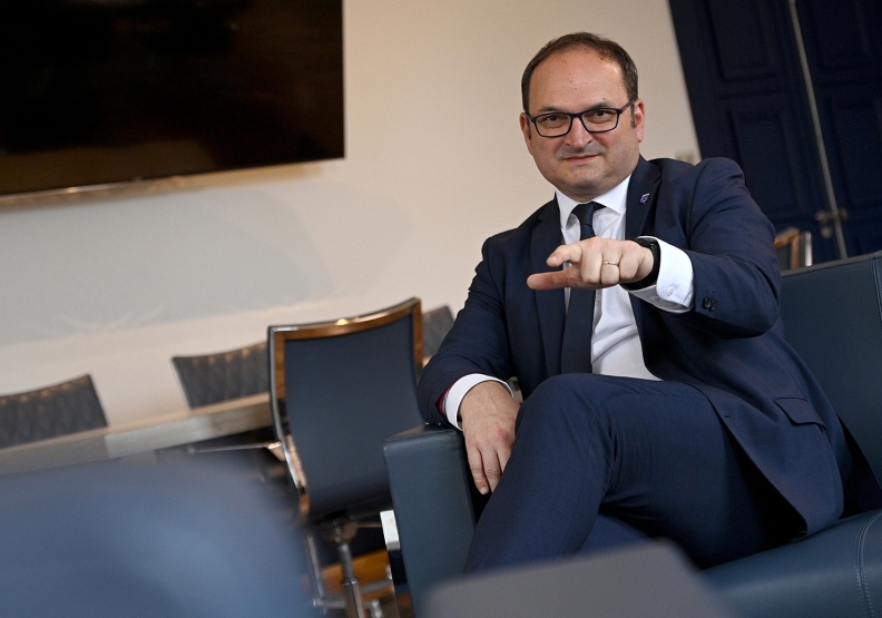 un homme en costume assis dans son bureau - Agrandir l'image, fenêtre modale